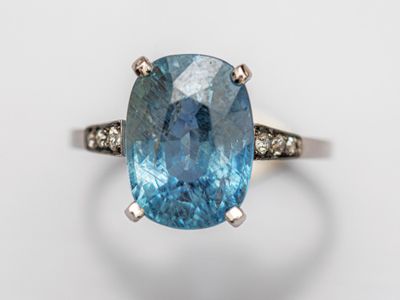 gros plan d'une bague avec une topaze bleue entourée de diamants