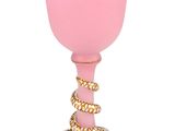 a pink glass with a gold rim and a rope around it