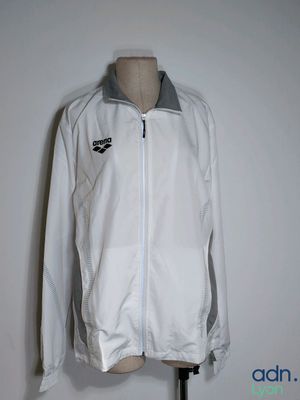 white jacket on a mannequin stand with a black and white logo