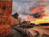 photo d'un coucher de soleil sur une plage, avec un château en arrière-plan