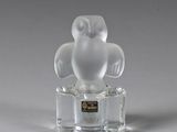 figurine en verre transparent représentant un hibou, posée sur un socle transparent