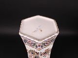 a small vase with a design on it on a black surface