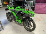 a green motorcycle that is parked in a garage