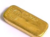 une barre d'or posée sur une surface blanche