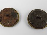two old buttons are sitting on a white surface