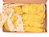 a box full of yellow yarn on a white surface