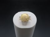 Gros plan sur une bague ornée d'une pièce d'or
