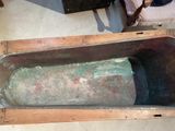 an old metal tub sitting on the floor next to a suitcase