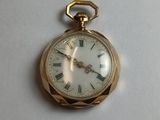 a gold pocket watch with roman numerals on it