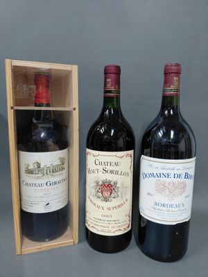 deux bouteilles de vin rouge dans un coffret en bois, à côté d'une bouteille de vin rouge