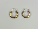 une paire de boucles d'oreilles en or sur fond blanc