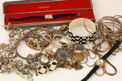 une boîte rouge remplie de nombreux bijoux, posée sur une table
