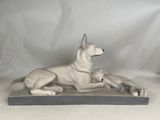 statue of a dog and a cat laying down on a table