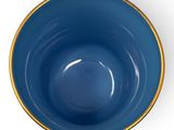 a close up of a blue bowl on a white surface