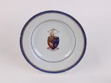 a white plate with a blue border and a picture of a knight on it