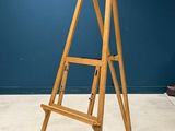 a wooden easer standing in a room with a blue wall