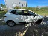 a small white car that is parked on the side of the road