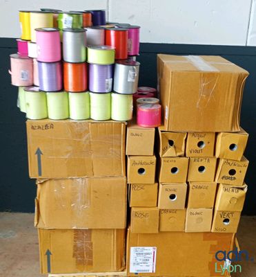 de nombreuses bobines de fil posées sur des cartons au sol