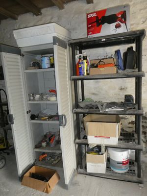 an open refrigerator in the middle of a room with tools