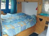 a bed in the back of a van with a blue comforter