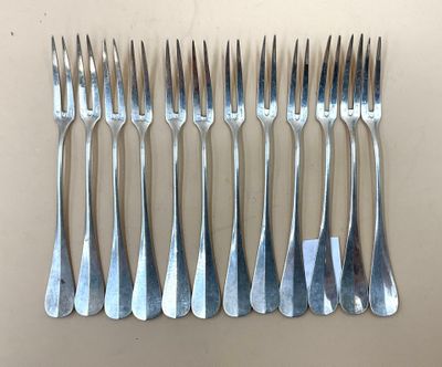 six fourchettes sont alignées en rang sur une table