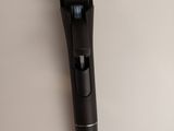 a black microphone on a white surface with a white background