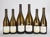 six bouteilles de vin sont alignées sur une table