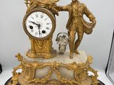 une statue d'un homme tenant une horloge au-dessus d'une table