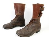 pair of brown leather boots with buckles and laces on them