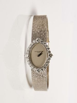 un gros plan d'une montre sur une surface blanche avec un fond blanc