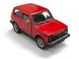 un camion jouet rouge posé sur une surface blanche