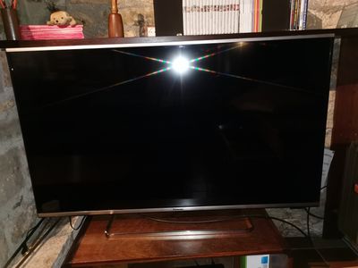 une télévision à écran plat posée sur une table en bois