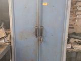 a blue metal cabinet in a room with tools on the table