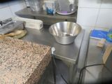 stainless steel counter top with a bowl and brush on it