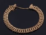 a gold chain bracelet on a black surface