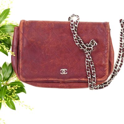 a brown purse with a chain hanging from it ' s side