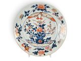 une assiette bleue et orange décorée de fleurs et d'oiseaux