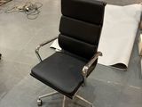 a black office chair and a black chair in the middle of a room