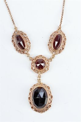 un collier en or orné d'une pierre noire et d'une chaîne en or