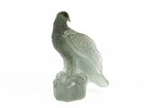 statue représentant un oiseau perché sur un rocher, posée sur un fond blanc