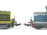 two toy trains sitting side by side on a white surface