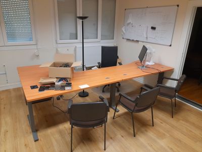 a desk with two chairs and a laptop on it
