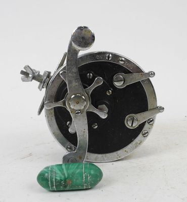a small metal object with a green stone on the ground