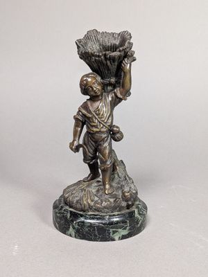 figurine en bronze représentant un garçon portant un panier de fleurs