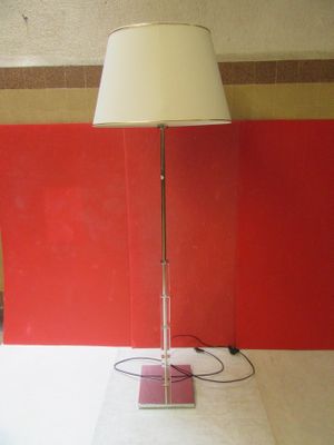 une lampe posée sur une table, avec un mur rouge en arrière-plan