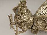 a metal bird that is sitting on a branch