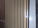 un lit dans une chambre dont le mur derrière est rayé