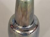 a silver vase with a blue lid on a white table