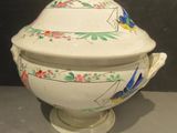 a white bowl with a lid and a handle on a table