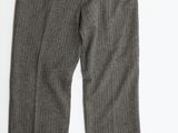 un gros plan du pantalon d'une personne posé sur une surface blanche